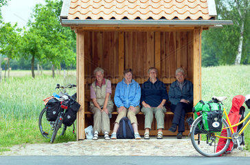 Wohlendorf  Deutschland  vier aeltere Damen pausieren bei einem Fahrradausflaug in einer Bushaltestelle