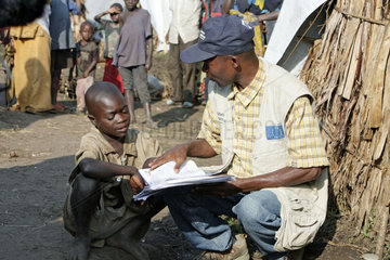 Minova  Demokratische Republik Kongo  Mitarbeiter von Malteser International mit einem Kind