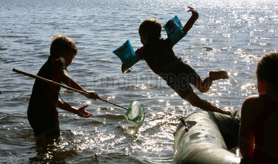 Wusterhausen  Deutschland  Silhouette von Kindern im Wasser beim Baden am See