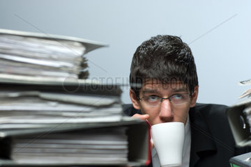 Riedlingen  Deutschland  ein Mann trinkt einen Schluck Kaffee waehrend der Arbeit