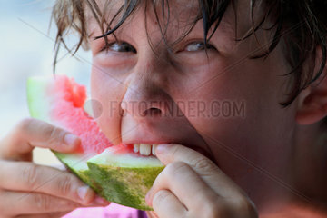 Alicudi  Italien  Junge isst ein Stueck Wassermelone