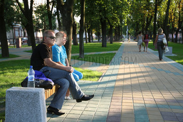 Brest  Weissrussland  ein Paar sitzt auf der Parkbank  der Mann raucht