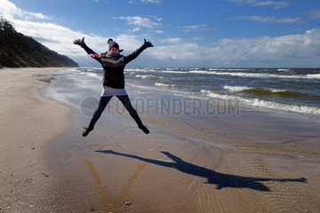 Kolberg  Polen  Frau macht einen Luftsprung am Strand