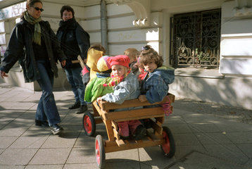 Kinder in einem Bollerwagen gezogen von Betreuern