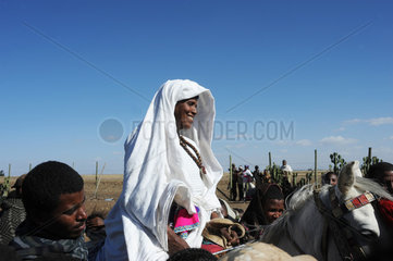 Mangudo  Aethiopien  Frau reitet auf einem Muli zur Schuleinweihung
