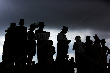 Ascot  Grossbritannien  Silhouette  elegant gekleidete Menschen vor dunklem Himmel