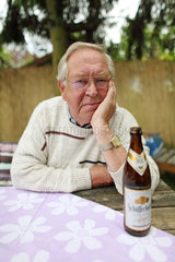 Berlin  Deutschland  Rentner mit Bierflasche schaut nachdenklich zum Betrachter