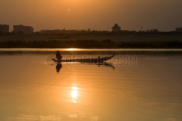 Phnom Penh  Kambodscha  ein Fischer auf seinem Boot im Sonnenuntergang
