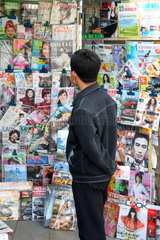 Peking  ein Mann steht vor dem Aushang eines Kiosks