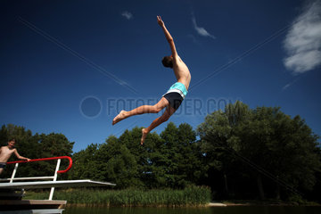 Neukloster  Deutschland  Junge springt von einem Sprungbrett ins Wasser