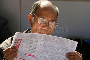 Hong Kong  China  Mann liest eine Zeitung