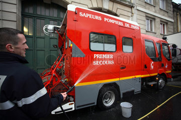 Paris  Frankreich  Feuerwehrmann waescht einen Feuerwehrwagen