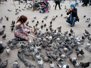 Amsterdam  Niederlande  eine Frau fuettert Tauben am Dam Square