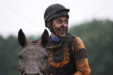 Hannover  Deutschland  Jockey lacht mit dreckverschmierten Gesicht beim Pferderennen