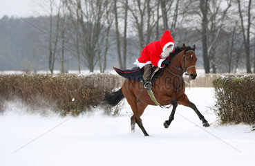 Hoppegarten  Deutschland  Weihnachtsmann reitet auf einem Pferd durch den Schnee