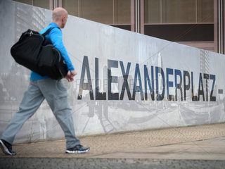 Berlin  Deutschland  ein Passant laeuft an einem Bauzaun am Alexanderplatz vorbei