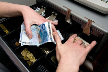 Berlin  Deutschland  eine Verkaeuferin nimmt 20 Euroscheine aus der Kasse