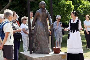 Wittenberg  Deutschland  Christiane Dalichow verkleidet als Katharina von Bora neben der Statue im Lutherhof