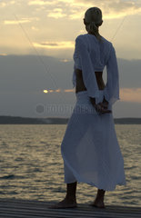 Junge Frau betrachtet entspannt den Sonnenuntergang  Bahamas