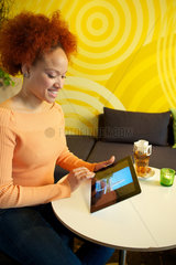 Hamburg  Deutschland  Frau sitzt mit ihrem iPad 2 in einem Cafe