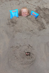 Santanyi  ein kleiner Junge ist im Sand eingebuddelt