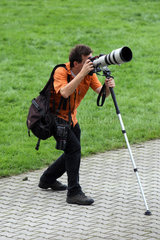 Iffezheim  Deutschland  Fotograf arbeitet mit einem Teleobjektiv