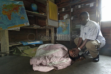 Goma  Demokratische Republik Kongo  Pastor betet fuer eine kranke Frau