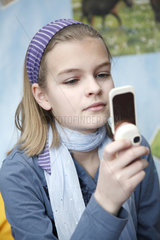 Hamburg  Deutschland  ein elfjaehriges Maedchen spielt mit ihrem Handy