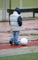 Berlin  Deutschland  Einsames Kind mit Fussball