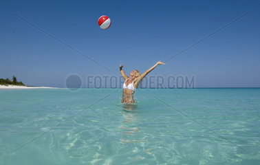 Junge Frau spielt mit einem Wasserball  Bahamas