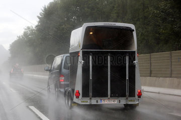 Salfaun  Oesterreich  Auto mit Pferdeanhaenger auf regennasser Autobahn