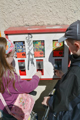 Berlin  Deutschland  Kinder an einem Kaugummiautomaten