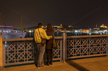 Istanbul  Tuerkei  ein Liebespaar auf der Galatabruecke bei Nacht