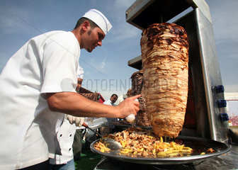 Dubai  Vereinigte Arabische Emirate  Koch schneidet Fleisch von einem Drehspiess ab
