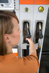 Euskirchen  Deutschland  eine Frau an der Zapfsaeule an einer Tankstelle
