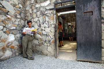Vietnam  Museumswaerter liest eine Zeitschrift