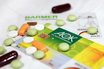 Berlin  Deutschland  Krankenkassenkarten der AOK und Barmer  daneben diverse Arzneimittel
