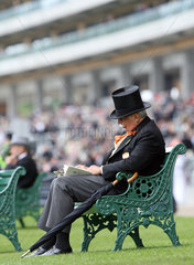Ascot  Grossbritannien  elegant gekleideter Mann sitzt auf einer Bank