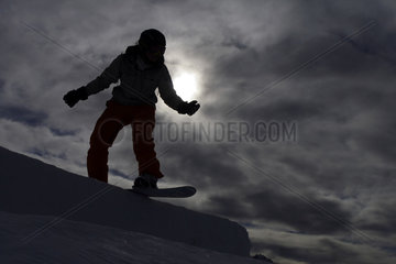 Innichen  Italien  Snowboarder auf der Piste im Gegenlicht