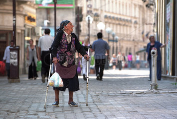 Eine alte Frau in einer Einkaufsstrasse in Bukarest