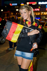Berlin  Deutschland  weiblicher Fussballfan mit Deutschlandfahne auf dem Kudamm