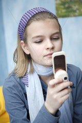 Hamburg  Deutschland  ein elfjaehriges Maedchen spielt mit ihrem Handy