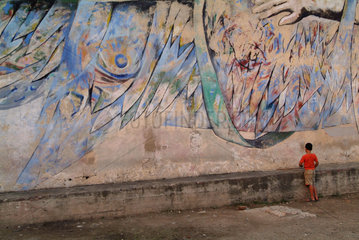 Santiago de Cuba  ein Junge vor einer bemalten Wand