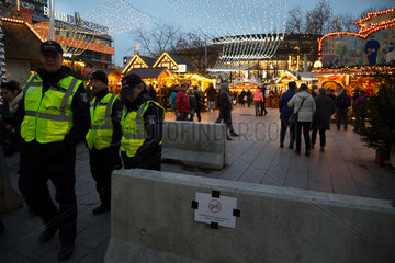 Deutschland  Berlin - Polizisten und Betonbarrieren am Weihnachtsmarkt (Gedaechtniskirche) zur Terrorabwehr