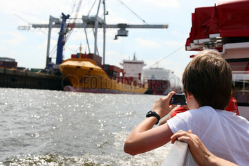 Hamburg  Deutschland  Junge fotografiert ein Containerschiff im Hamburger Hafen