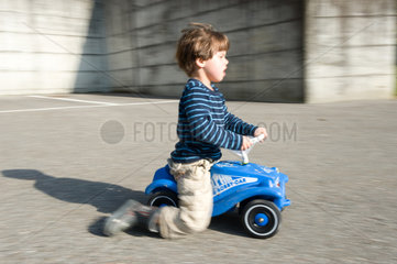 Carabietta  Schweiz  Junge faehrt mit einem Bobby Car