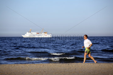 Mann joggt am Strand an der Ostsee