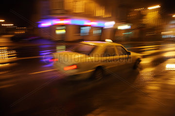 Zoppot  Polen  ein Taxi faehrt nachts auf der regennassen Hauptstrasse