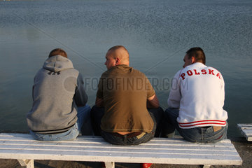 Skorzecin  Polen  drei junge Maenner an einem See