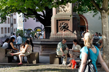 Freiburg im Breisgau  Deutschland  Menschen sitzen an einem Brunnen in der Altstadt